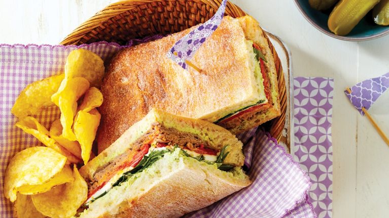 basket with sandwich on ciabatta with potato chips on the side